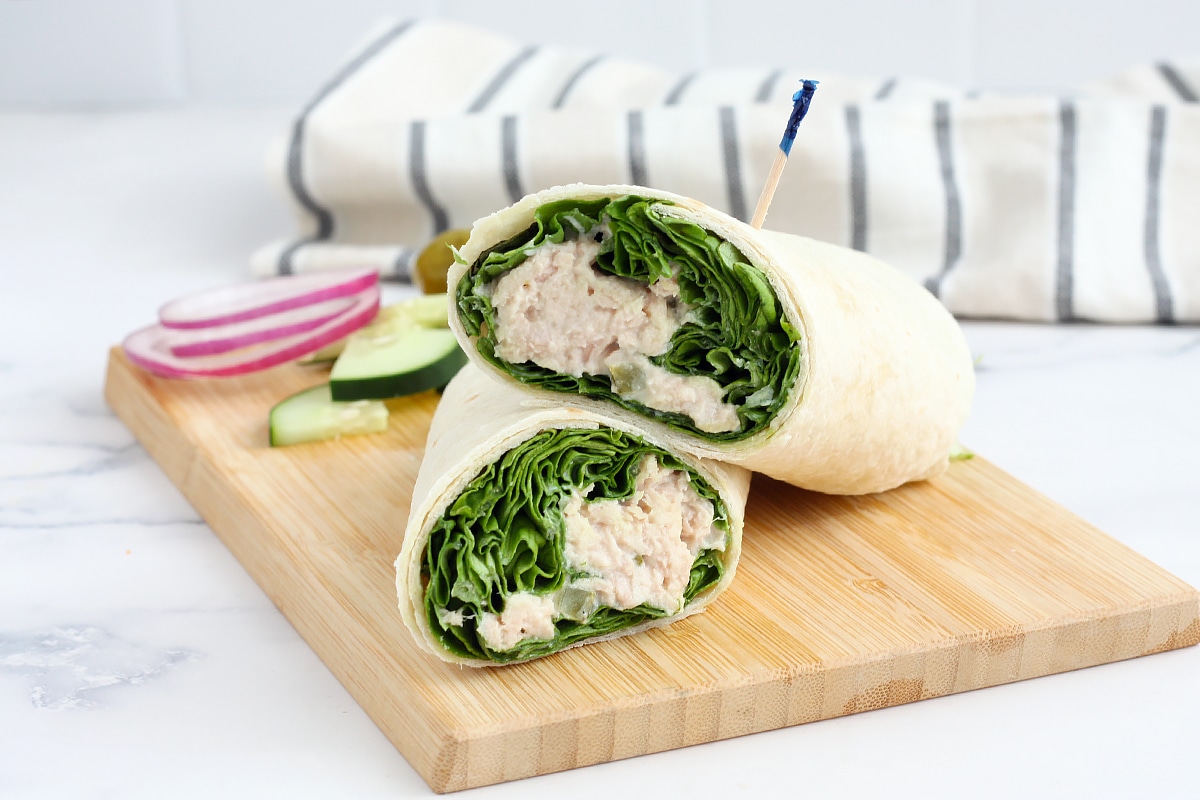 protein packed tuna wraps with lettuce on a cutting board with fresh cucumber