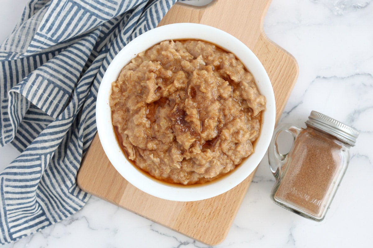 snickerdoodle oatmeal in a serving bowl with cinnamon sugar on the side
