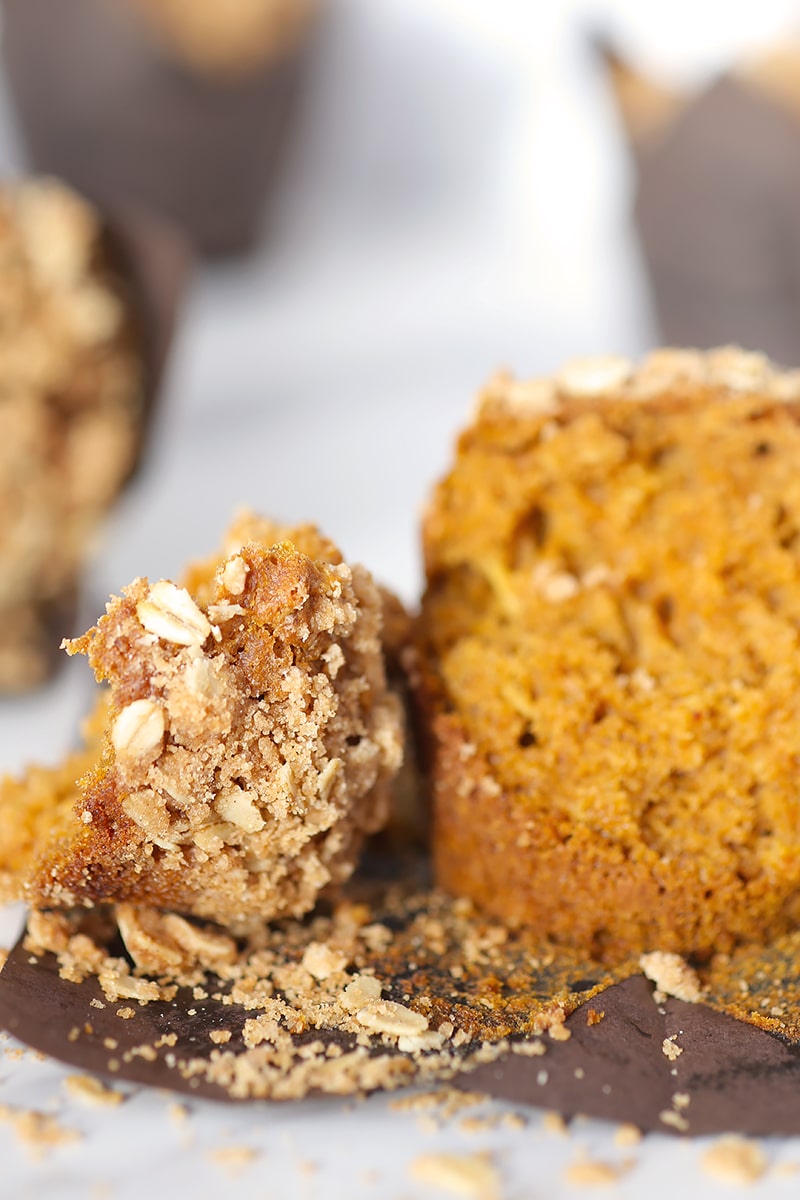 pumpkin streusel oat muffin broken in half on a muffin paper