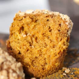 pumpkin streusel oat muffin broken in half on a muffin paper