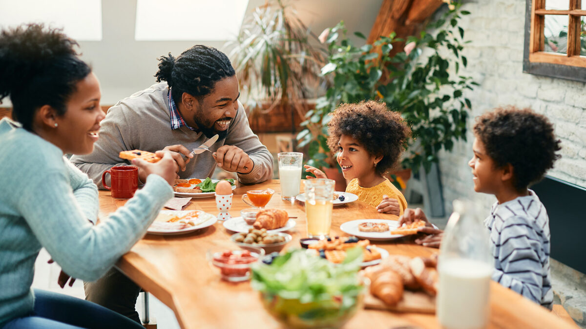 Family happily gathered around dinner table for a meal