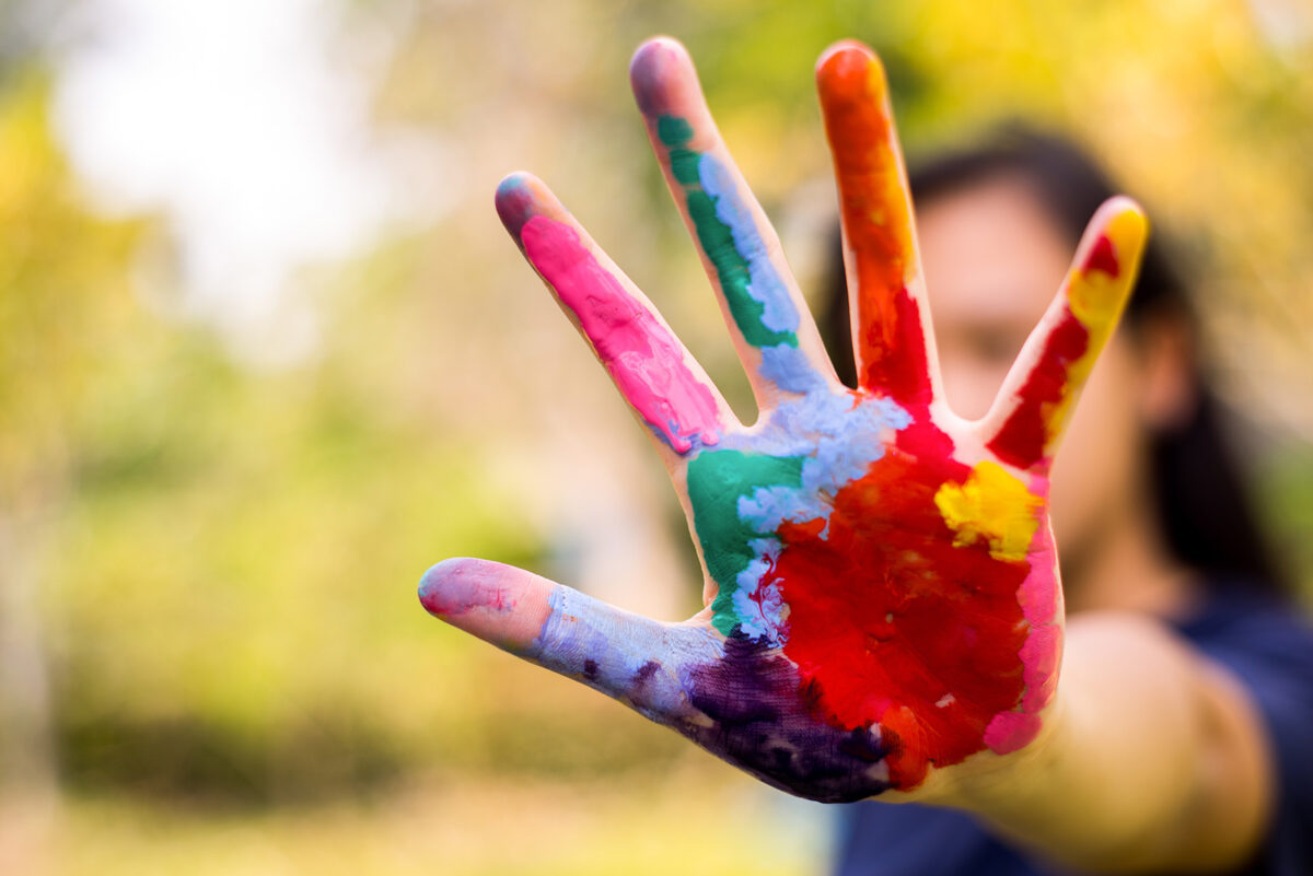 Child with colorfully painted hand