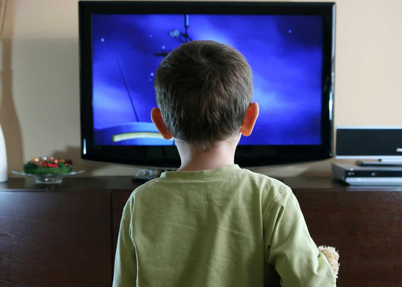 Looking at the back of a young boy's head as he stares at a TV screen