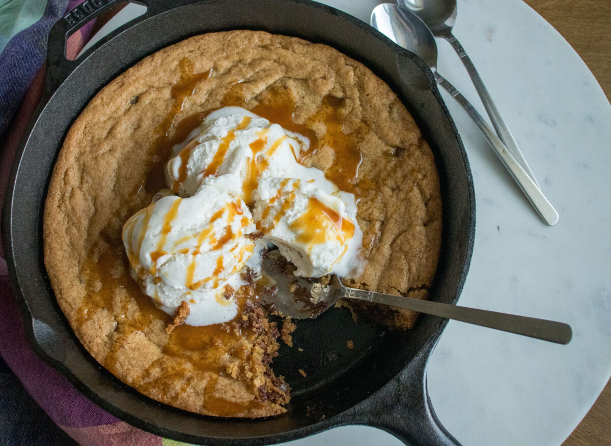 Warm skillet cookies topped with vanilla ice cream and drizzled caramel sauce.