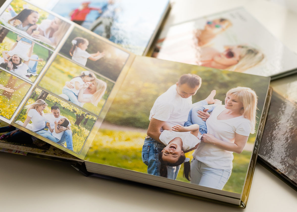 Family photo book opened to a page with mom and dad holding child upside-down