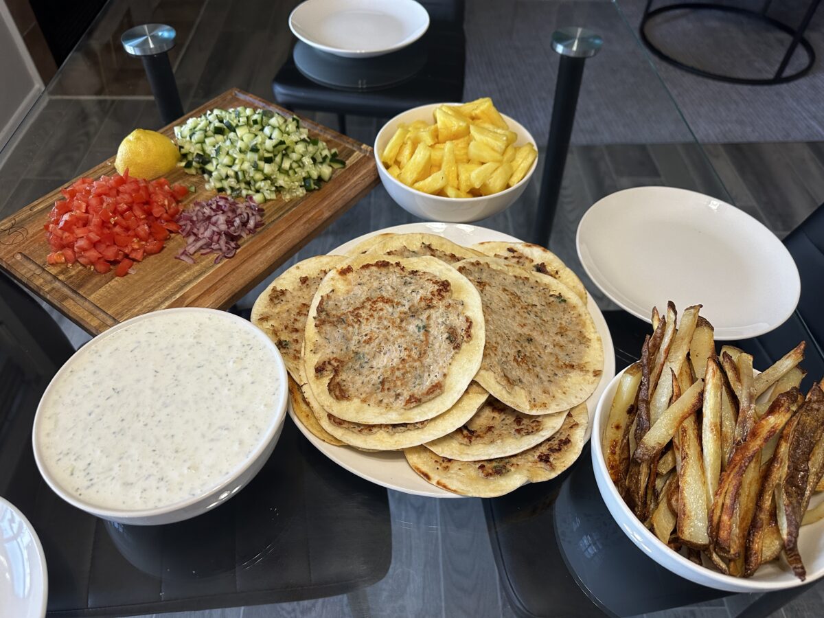 Chicken Gyro Tacos on a serving plate with diced pineapple, homemade french fries and tzatziki sauce. 