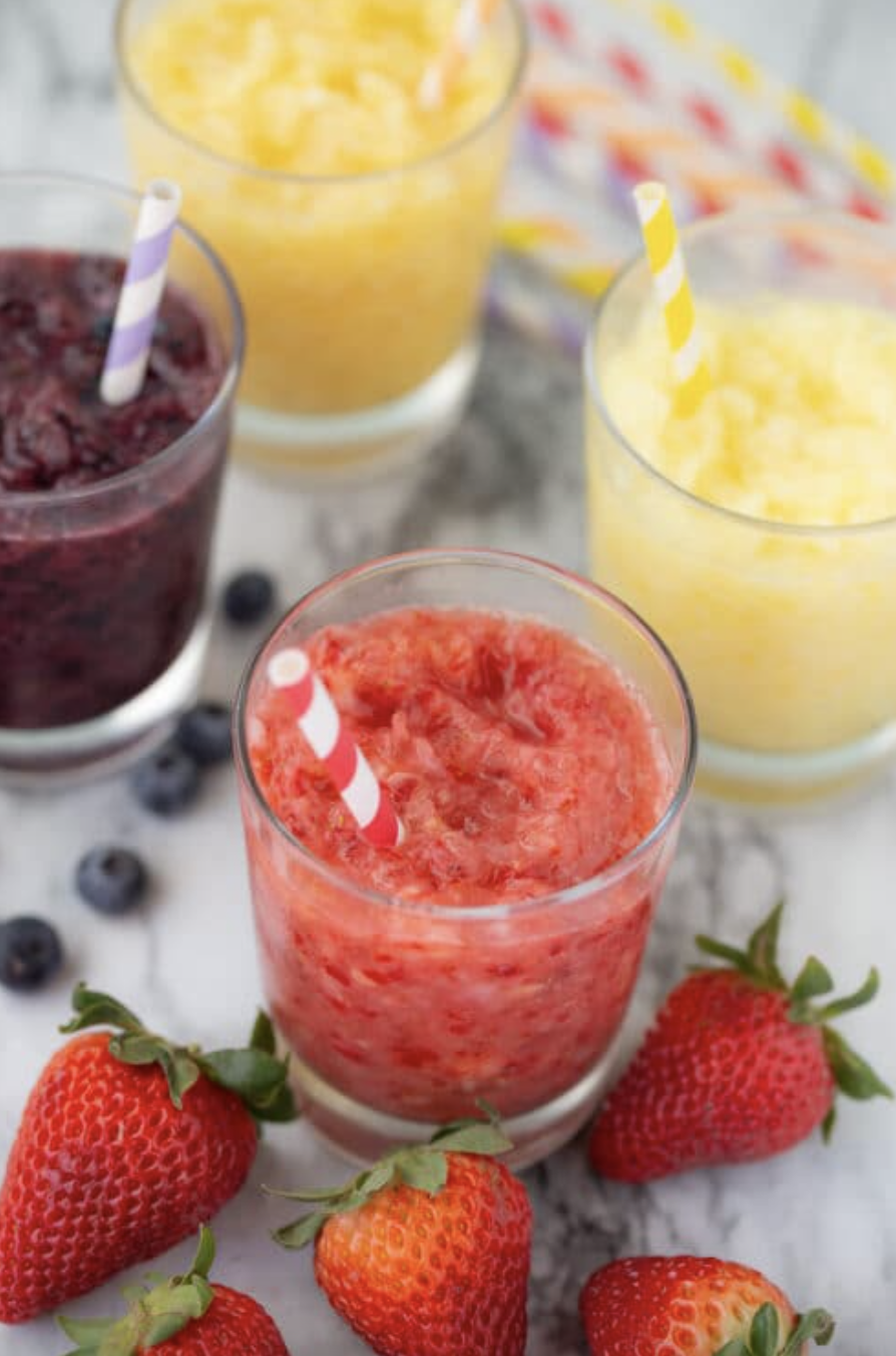 clear glasses with colorful striped straws filled with fruit slushies in different flavors