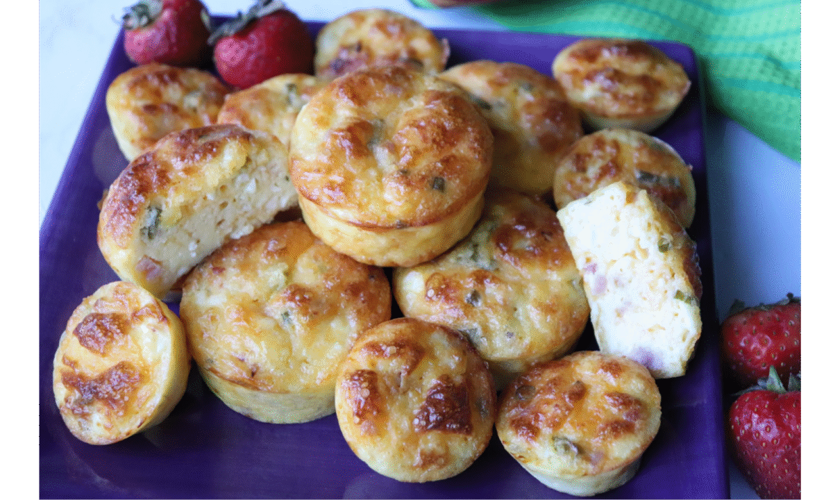 easy breakfast egg puffs stacked on a blue plate served with strawberries