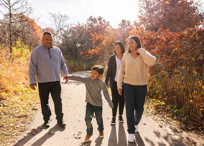 Father, mother, daughter, and son walking on a nature trail together, developing strong family habits