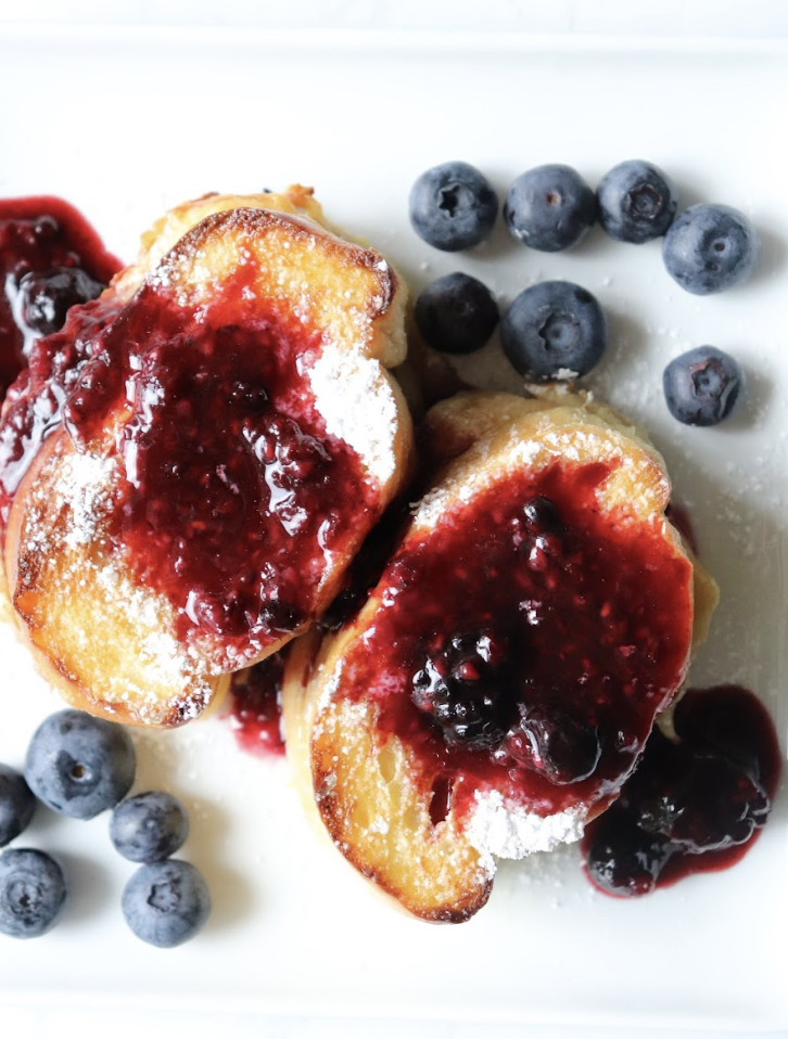 overnight stuffed french toast with powdered sugar and raspberry syrup