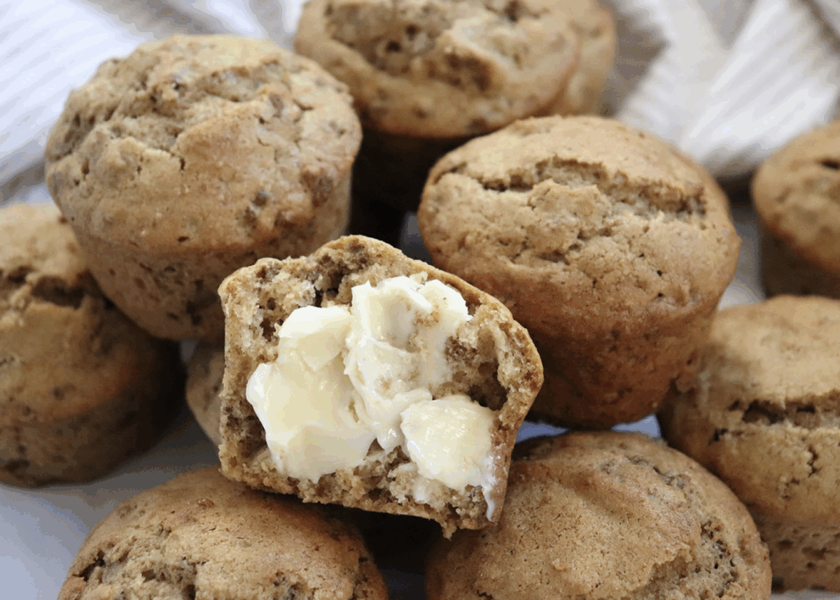 healthy bran muffins piled on a striped linen, spread with butter