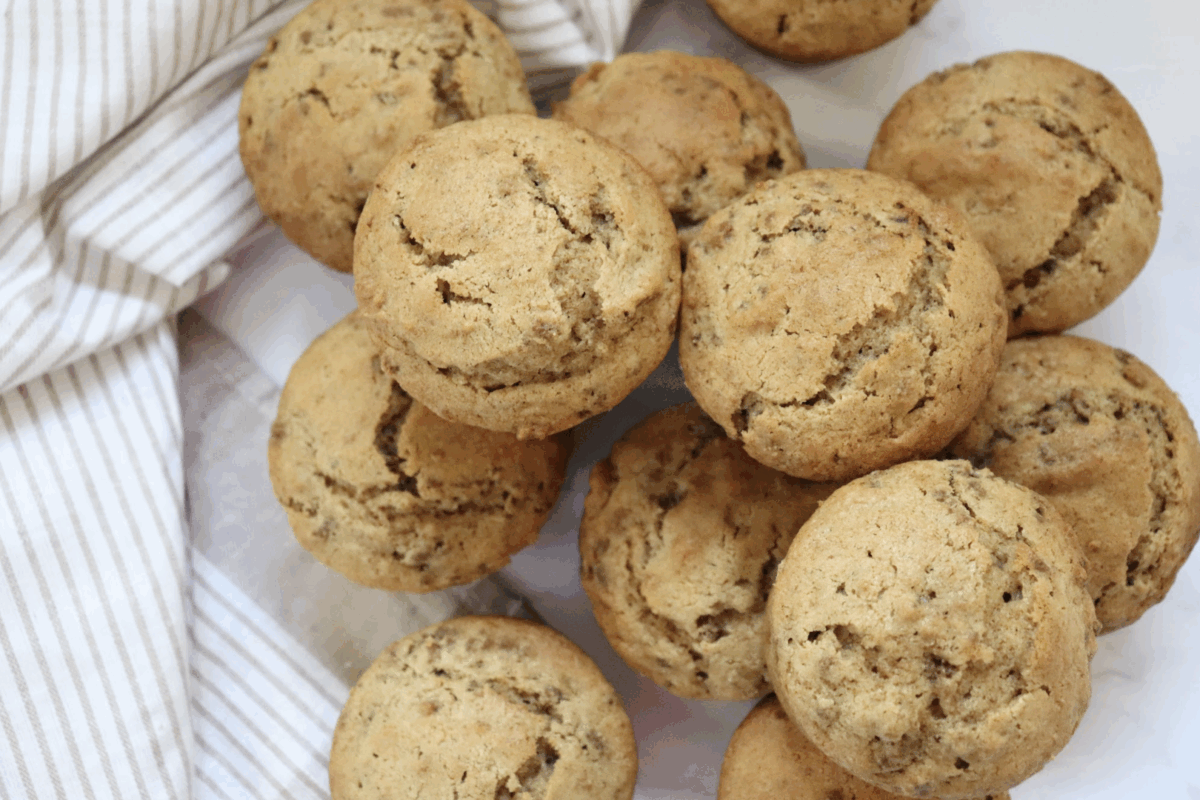 healthy bran muffins piled up on a striped linen