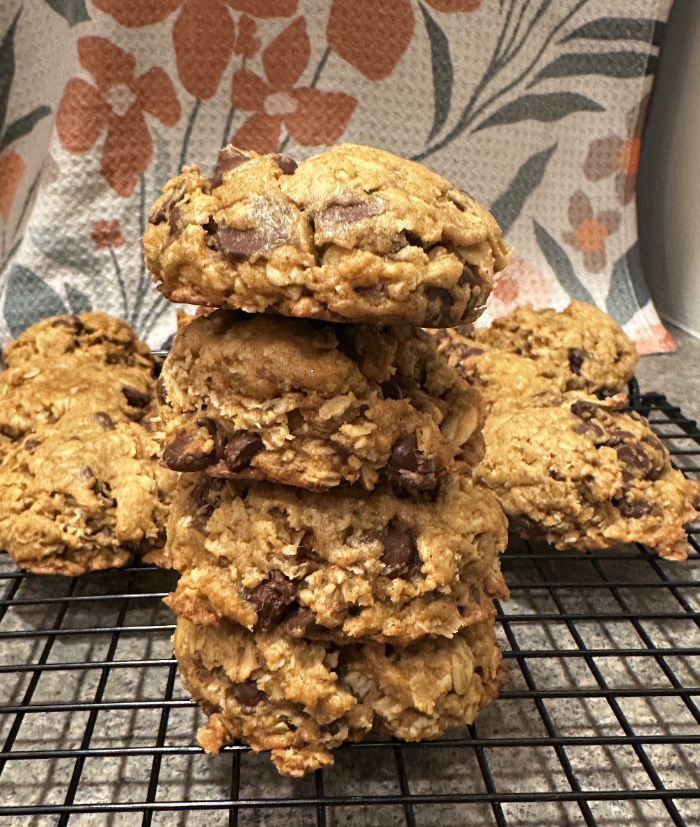 pumpkin chocolate chip cookies stacked on top of each other with a floral linen in the background