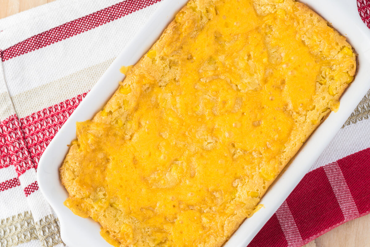 Close up of casserole dish with fresh baked homemade creamy cheese corn casserole.