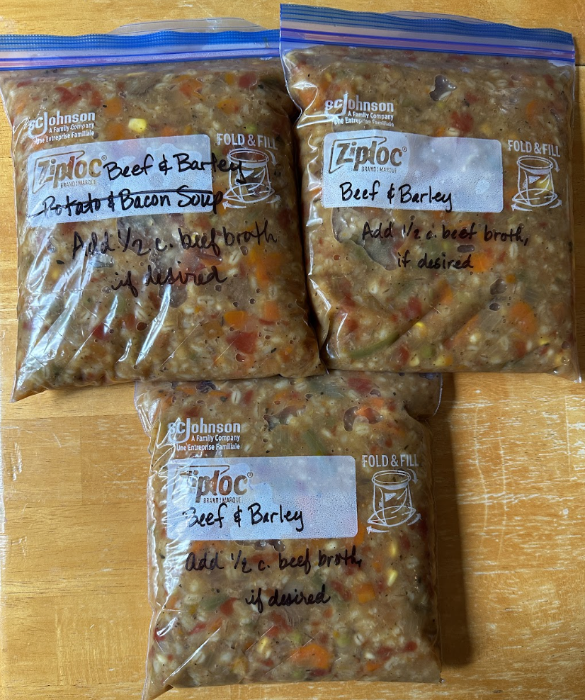 beef and barley soup in freezer bags on a wooden countertop