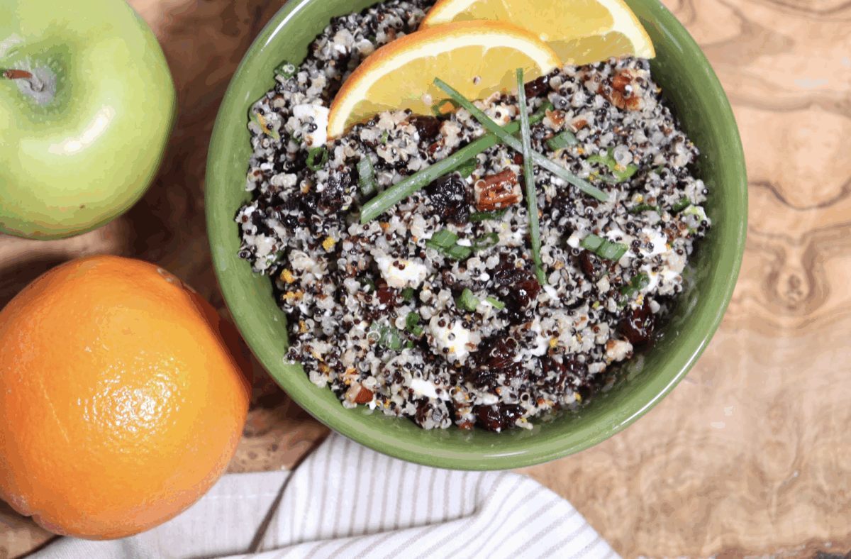 cranberry quinoa salad with feta, pecans, and apple in a serving bowl