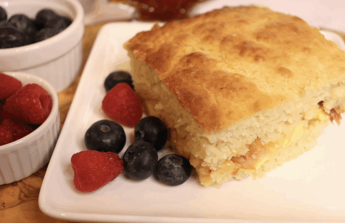 pancake casserole with eggs and sausage on a plate with fresh berries