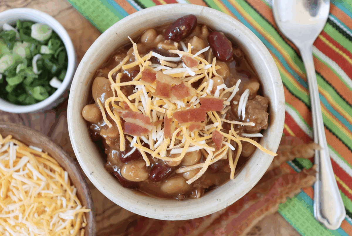 sweet chili in a serving bowl topped with shredded cheese and bacon bits