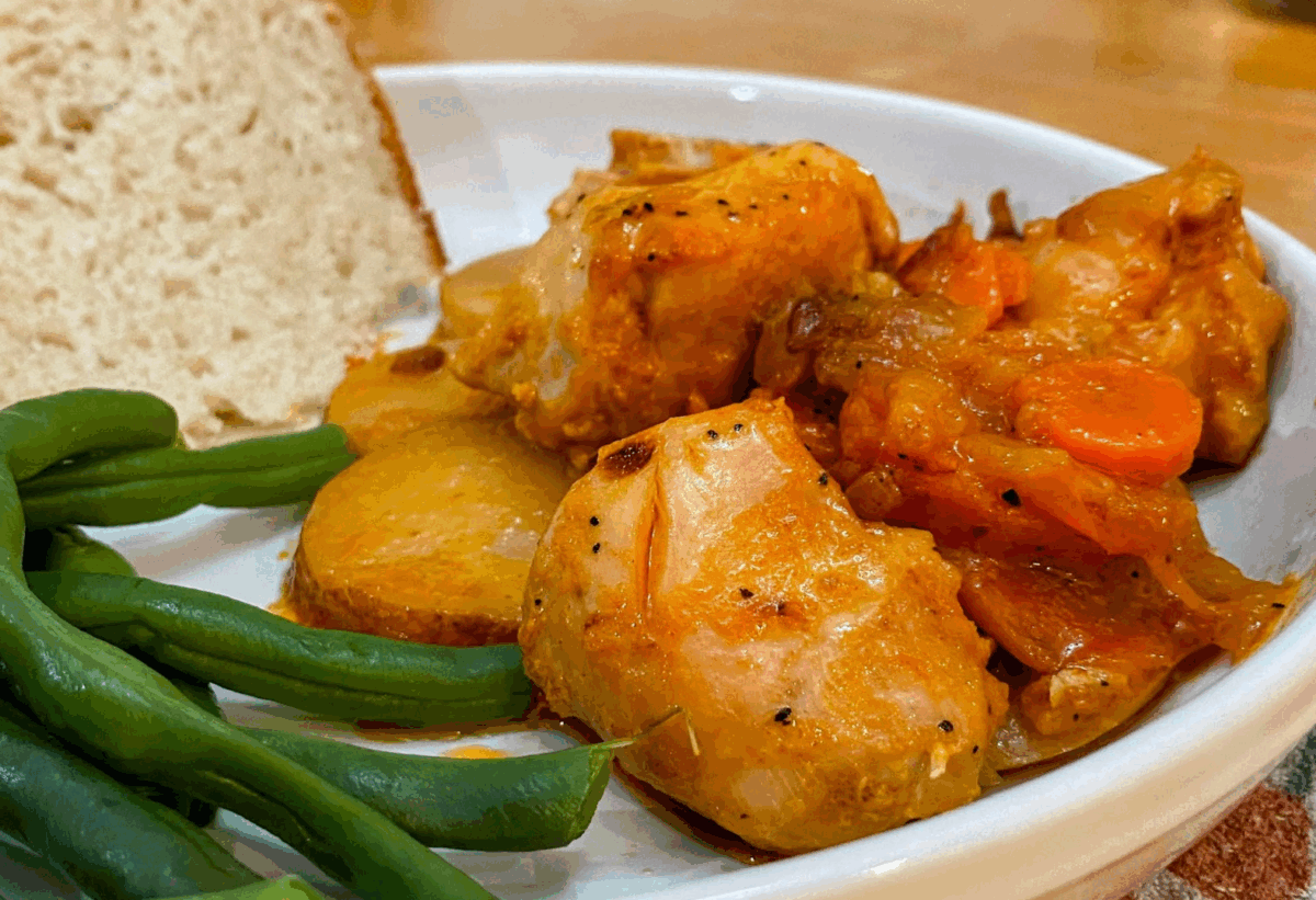 dutch oven chicken with carrots and onions served with fresh bread and green beans