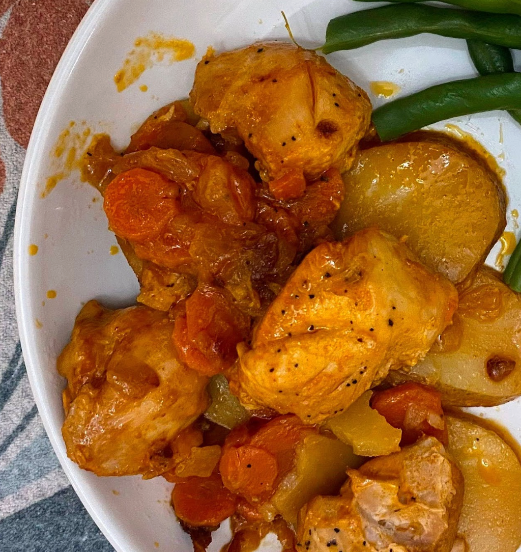 dutch oven chicken with potatoes and carrots on a plate with green beans