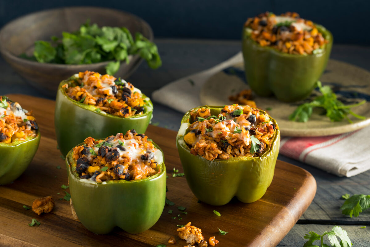 stuffed bell peppers with black beans and corn on a wooden serving board