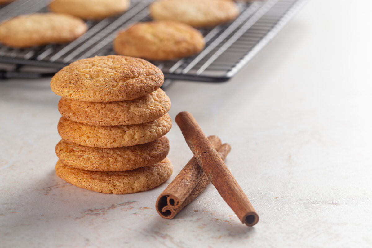 a stack of snickerdoodle cookies with cinnamon sticks on the side