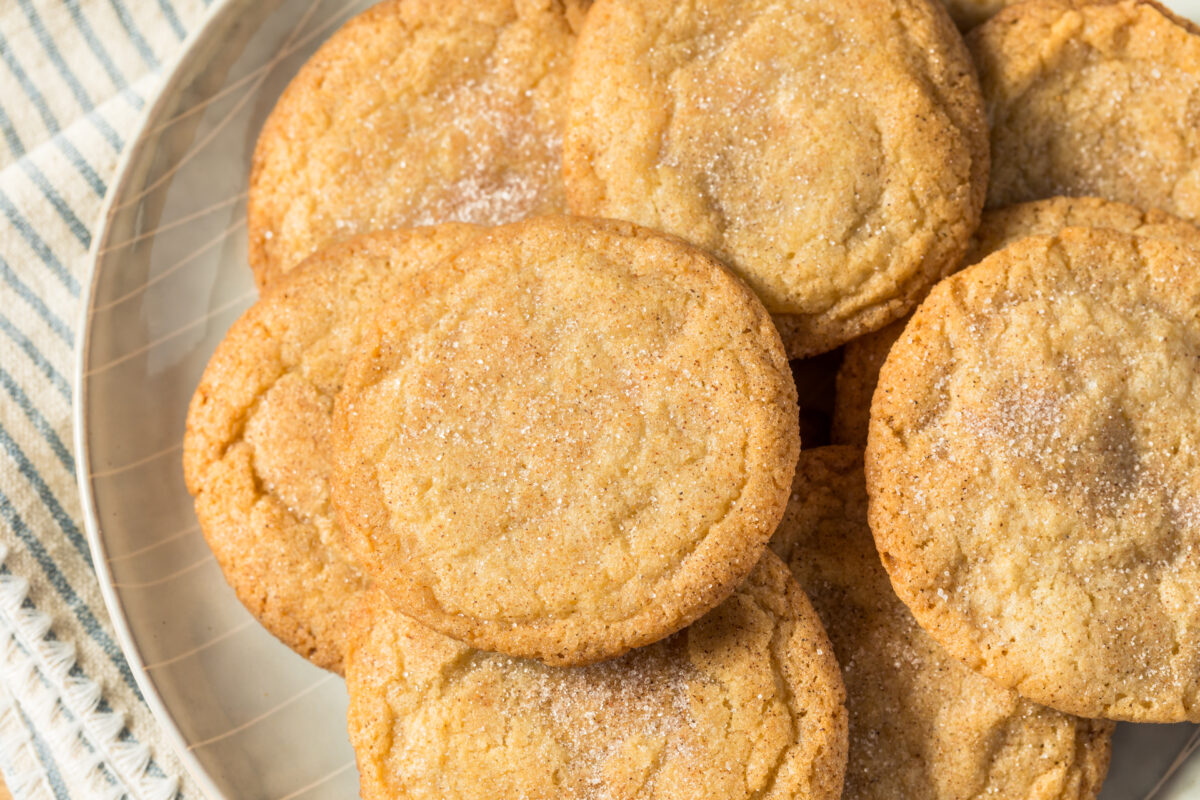snickerdoodle cookies on a serving plate with a striped linen