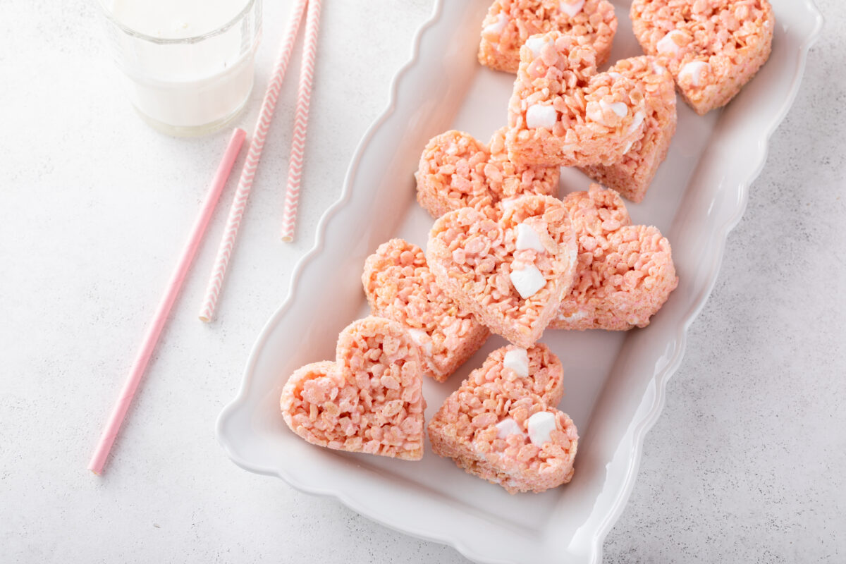 Pink heart shaped rice krispie treats served with milk, homemade sweet treat for Valentines Day