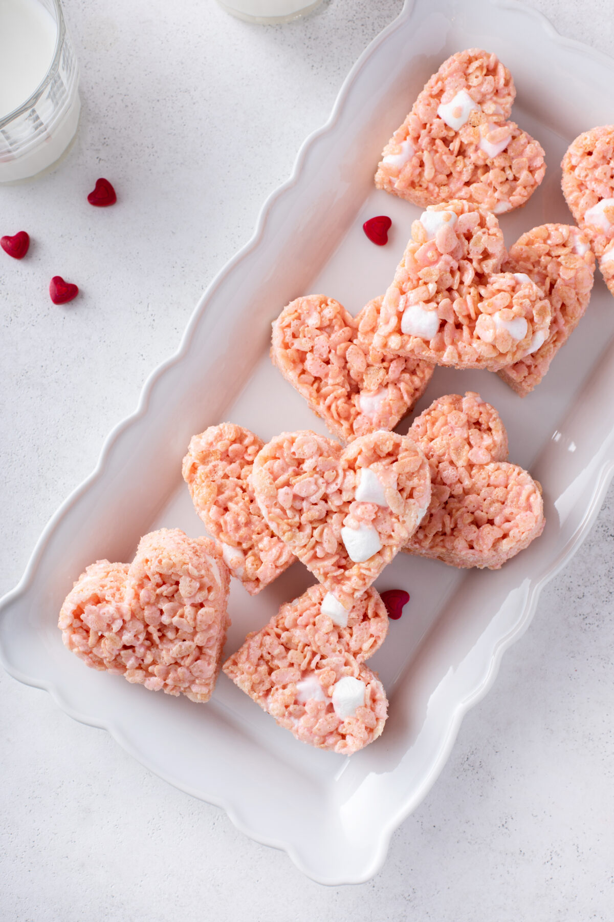 Pink heart shaped rice krispie treats served with milk, homemade sweet treat for Valentines Day
