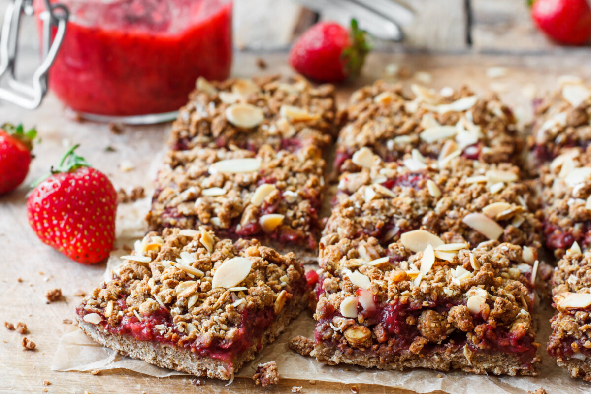 strawberry oat bars with sliced almonds cut into squares with fresh strawberries