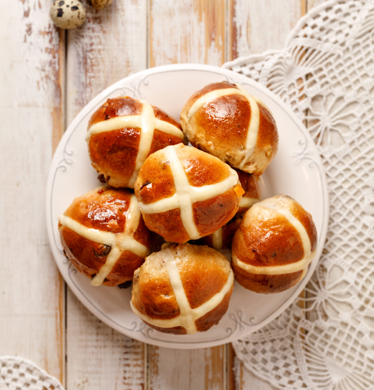 Traditional hot cross buns with sparkling glaze on a serving plate