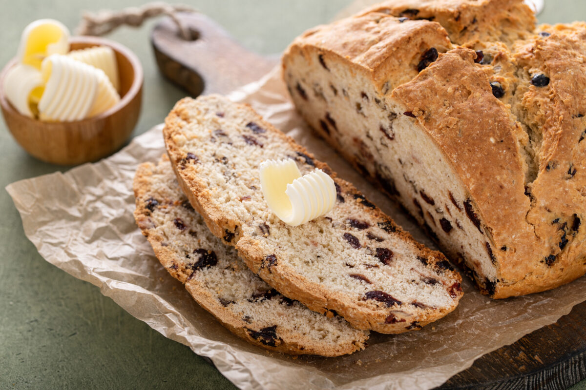 the best irish soda bread with currants cut into slices with fresh butter