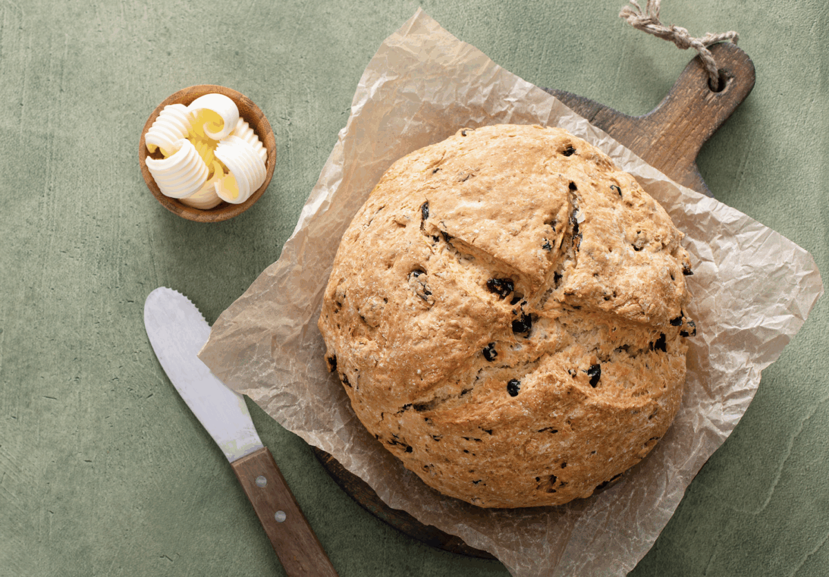 Close-up of a rustic loaf of Healthy Irish Soda Bread showing the traditional cross cut and golden crust.