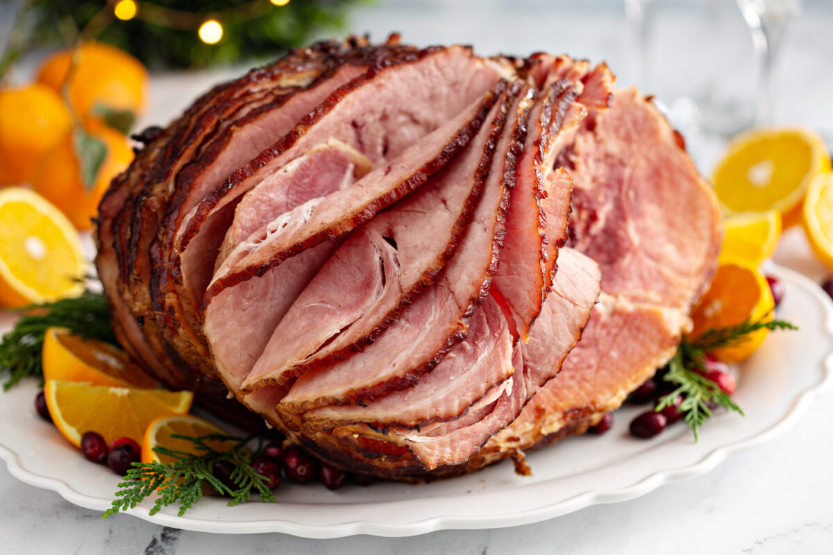 Spiral cut Christmas ham with orange honey glaze on a serving plate