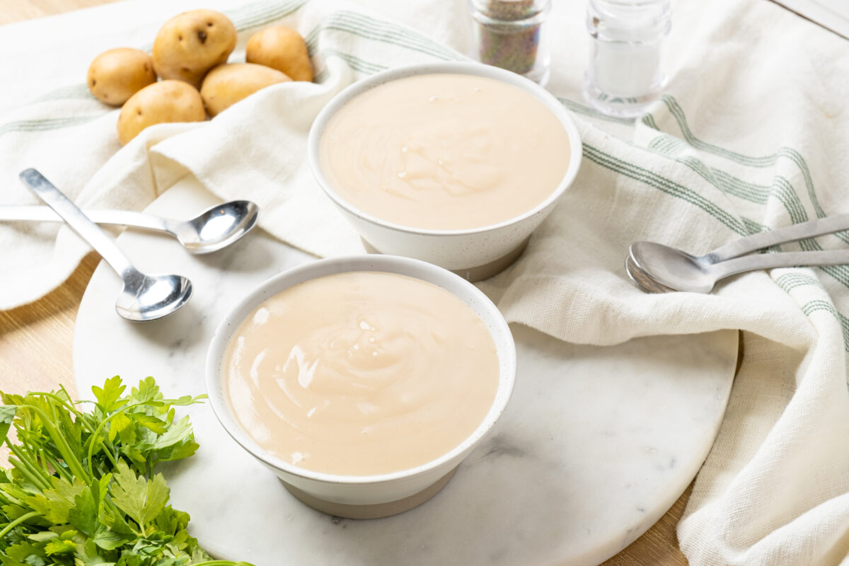 bowls of creamy potato leek soup with a striped linen
