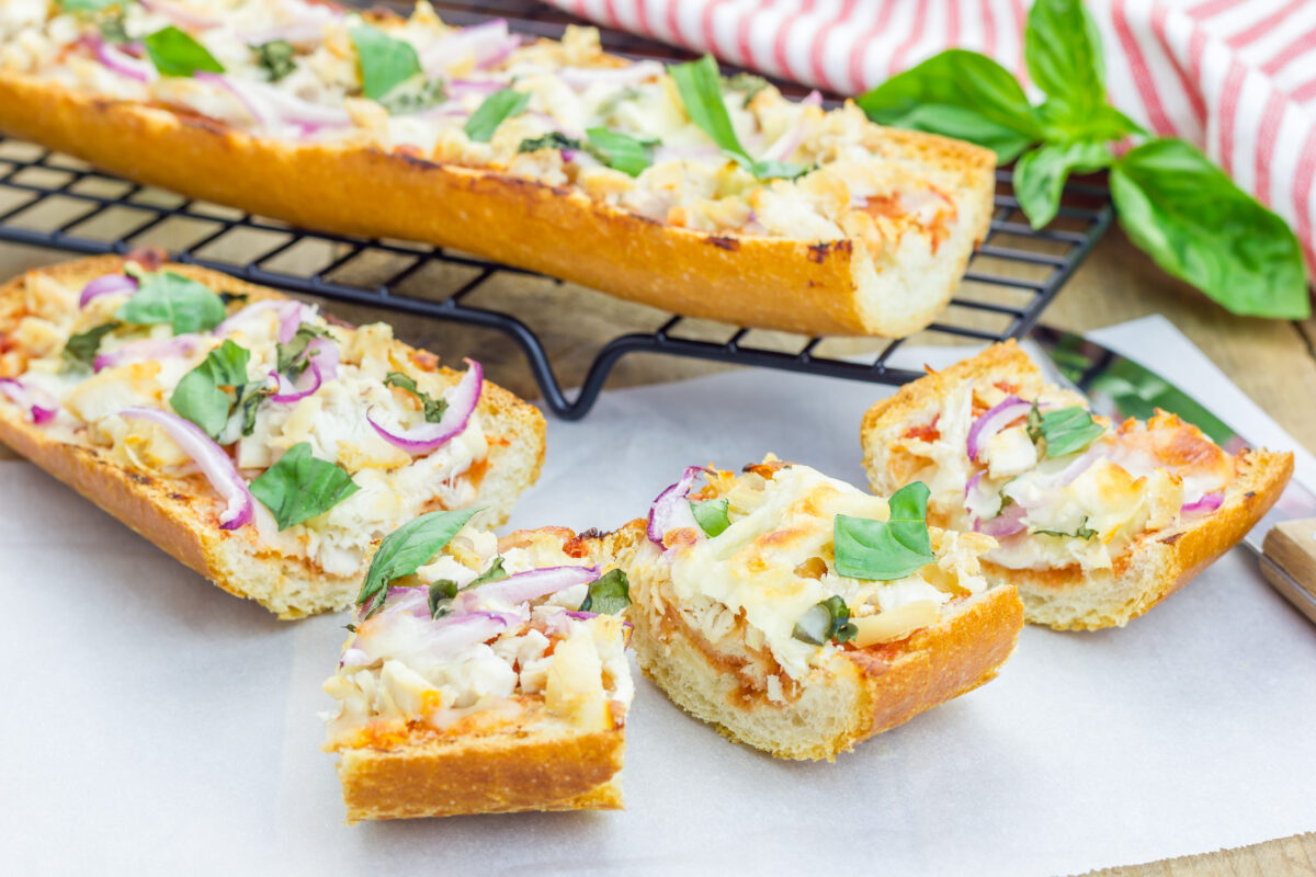 Barbecue chicken pizza baguette with fresh basil cut into slices