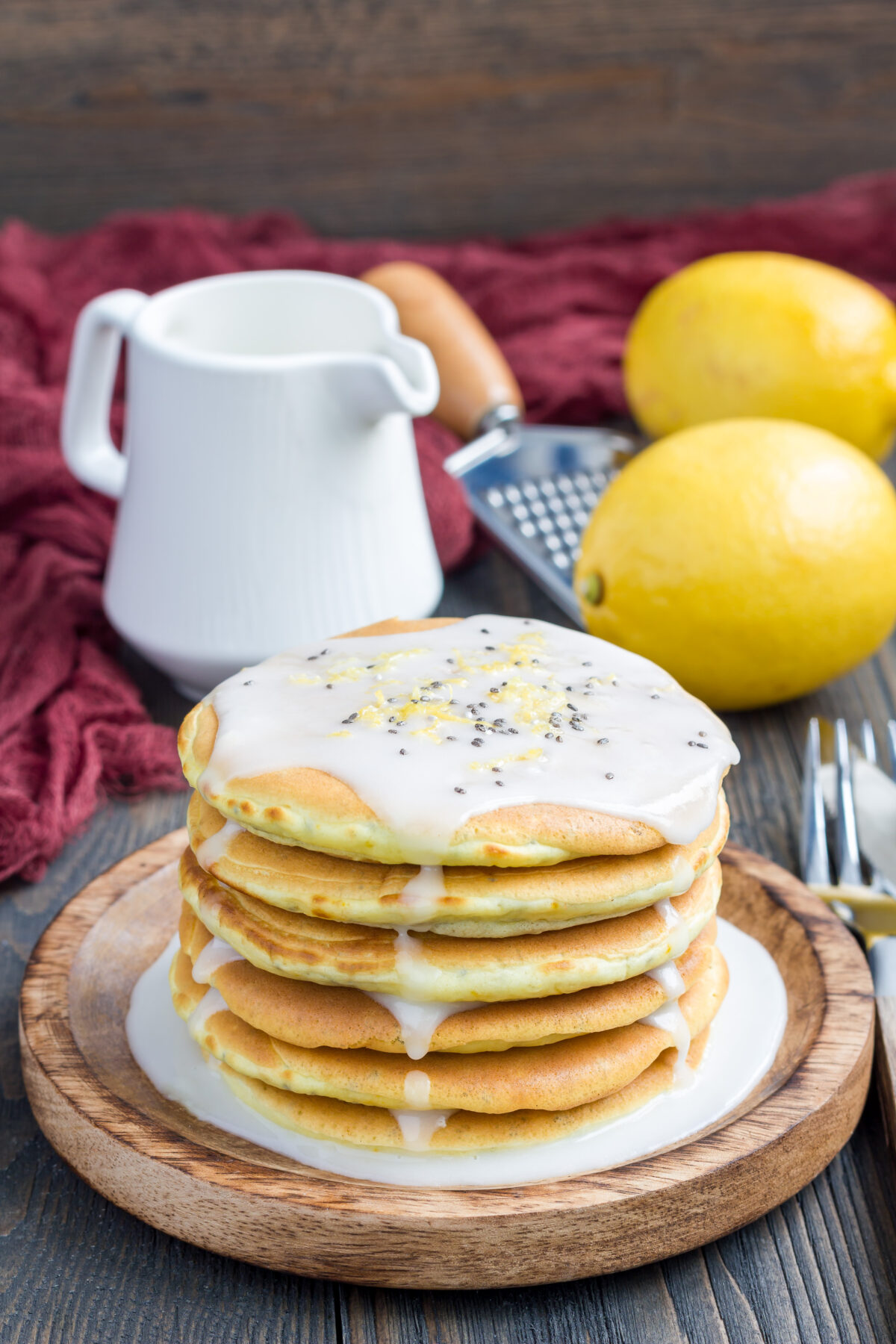Homemade lemon and chia seed pancakes with citrus glaze on a wooden plate