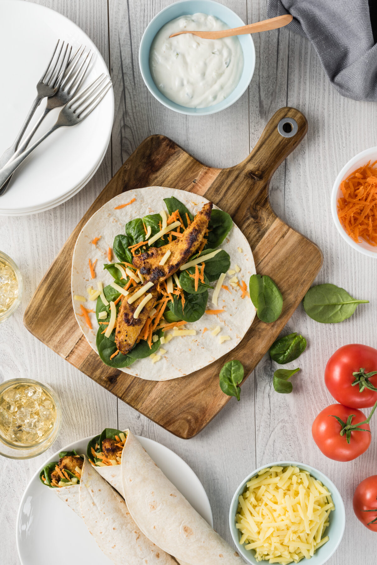 Fresh healthy chargrilled tandoori chicken wrap with tzatziki, cheese, baby spinach and carrots