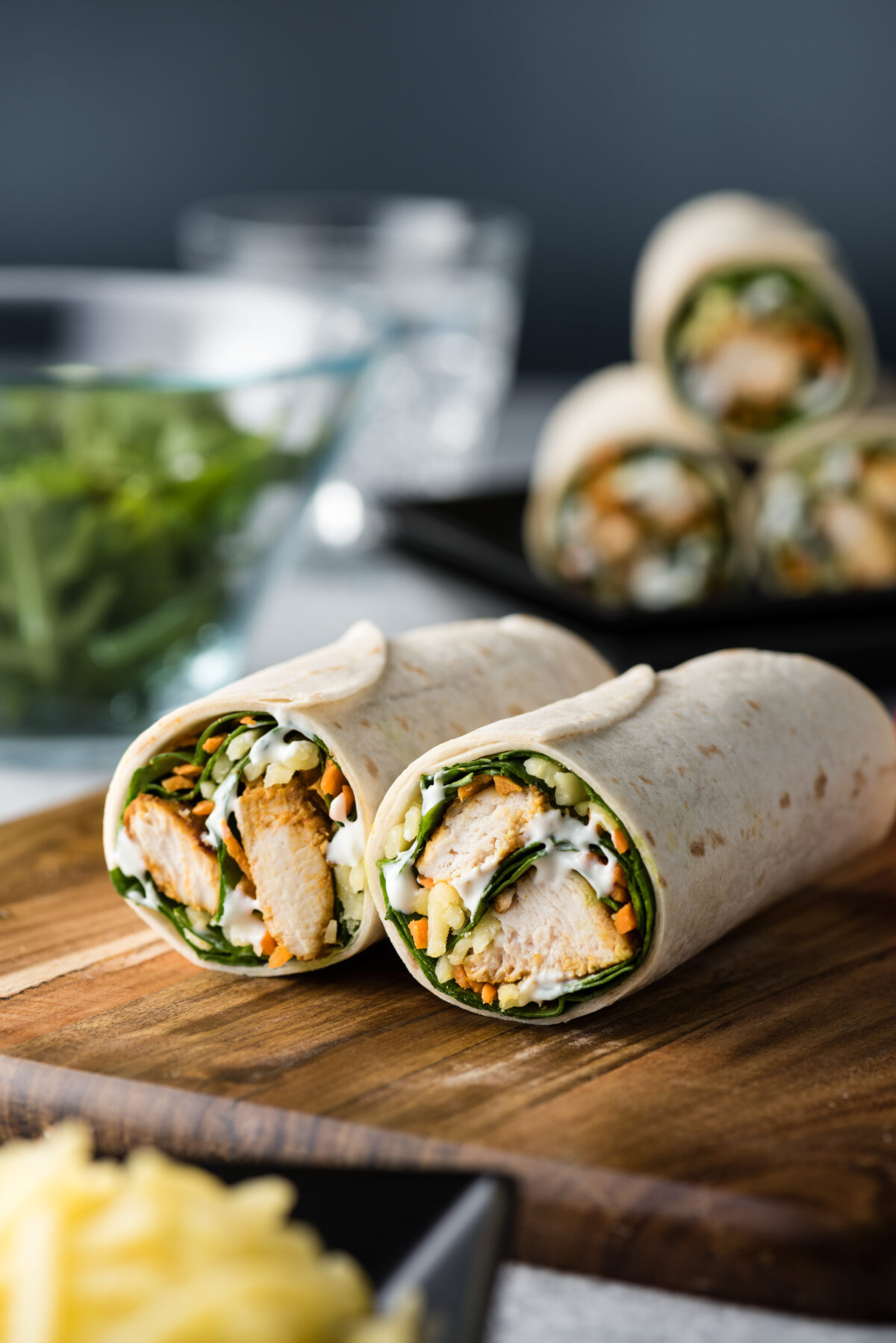 Fresh healthy chargrilled tandoori chicken wrap with tzatziki, cheese, baby spinach and carrots