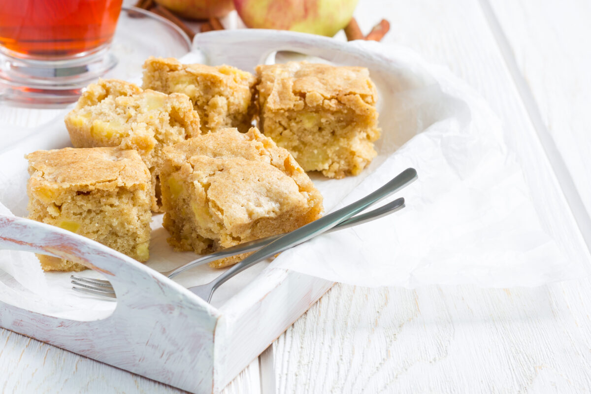 Apple blondies cut into squares on a serving plate with fork