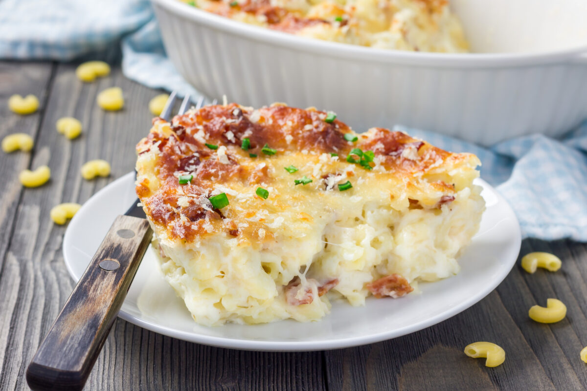 baked mac and cheese with bacon scooped onto a serving plate