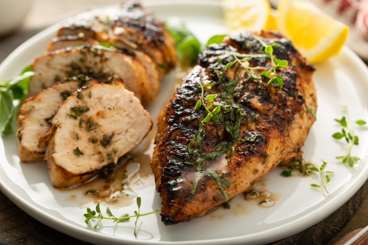 balsamic grilled chicken with fresh thyme and lemon on a serving plate