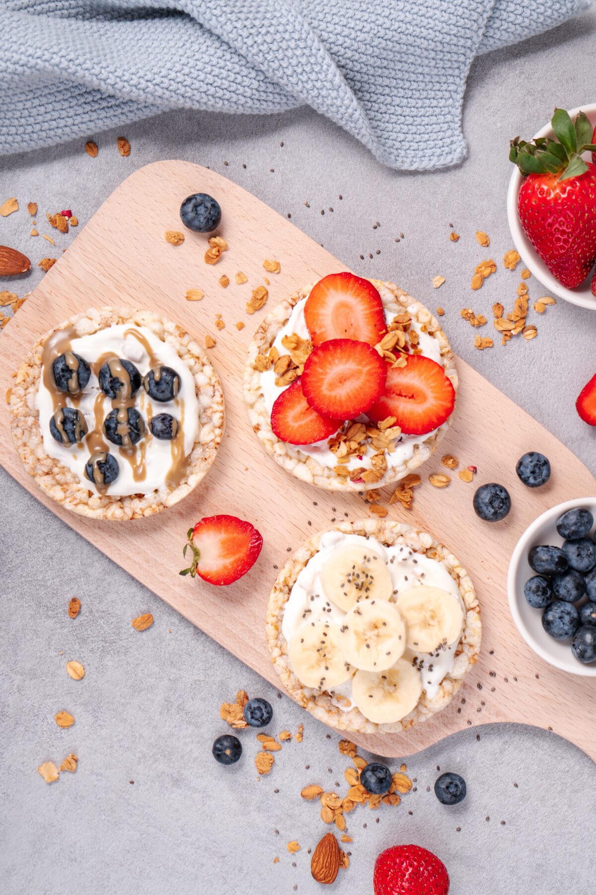 healthy snack cakes topped with fresh fruit and yogurt on a wooden cutting board
