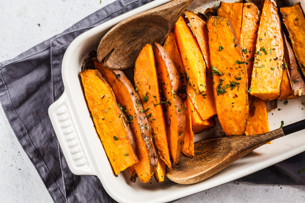 Baked sweet potato slices with spices in the oven dish. 