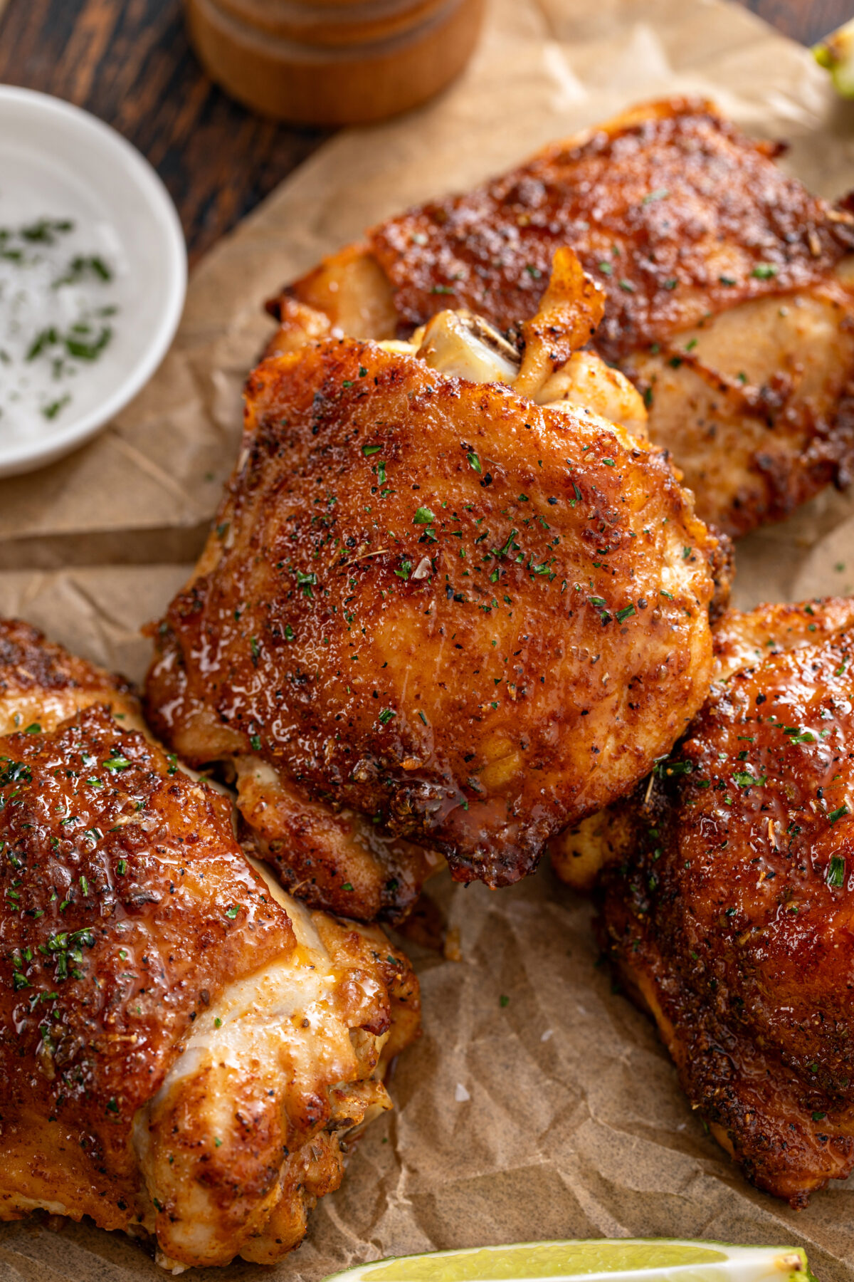 Chicken thighs roasted or air fried with paprika, spices rub and lime on a cutting board