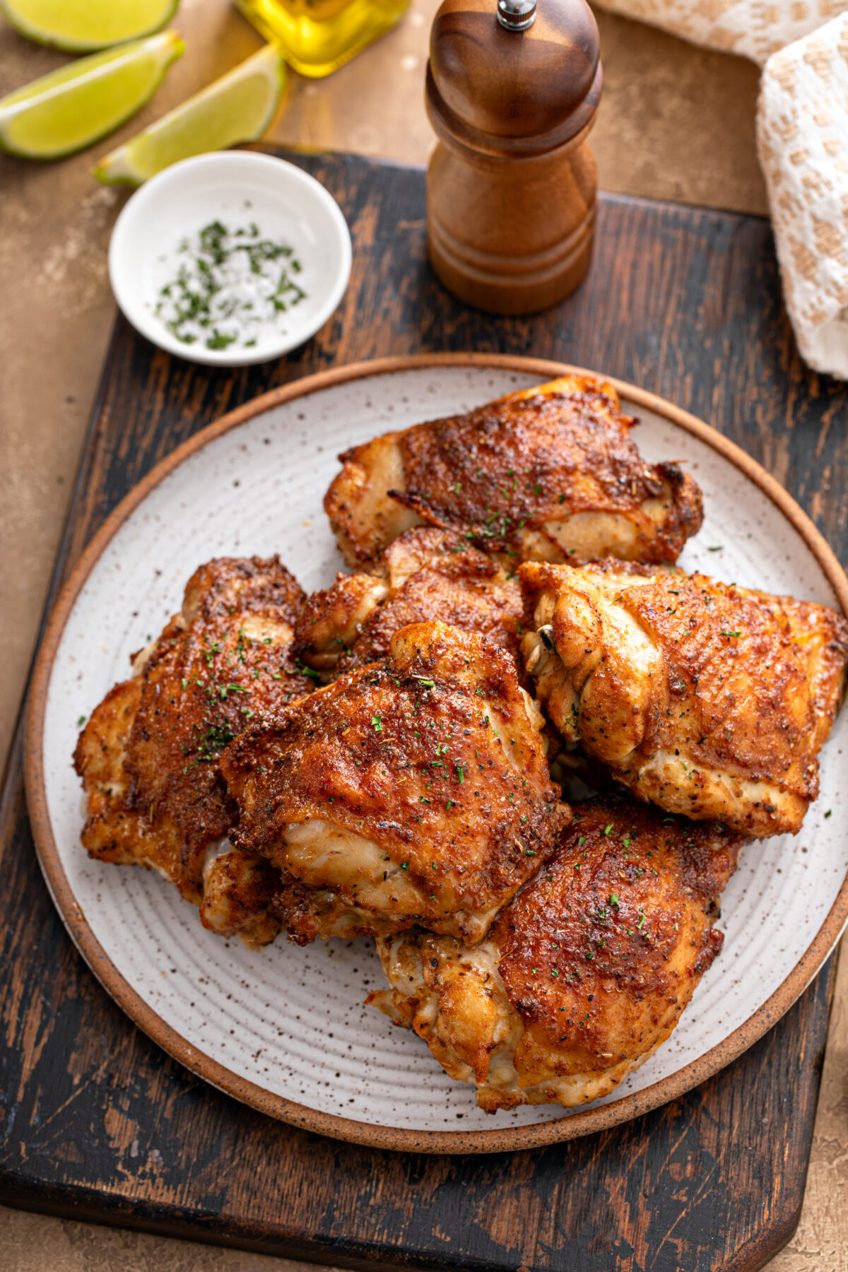 Chicken thighs roasted or air fried with paprika, spices rub and lime on a plate