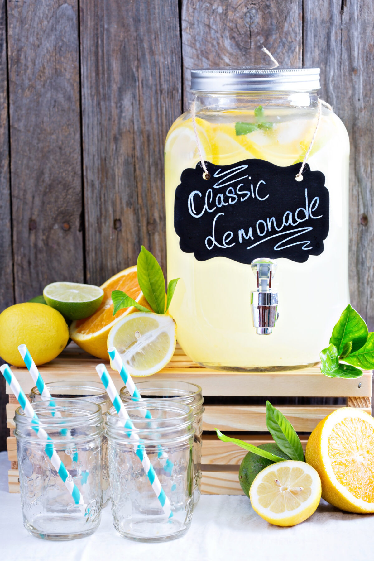 Homemade lemonade in beverage dispenser with fresh lemons