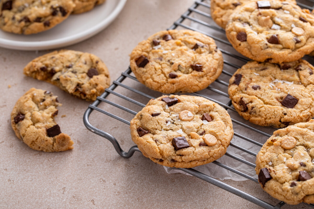 Chocolate chip cookies with chocolate chunks and caramel chips on a cooling rack