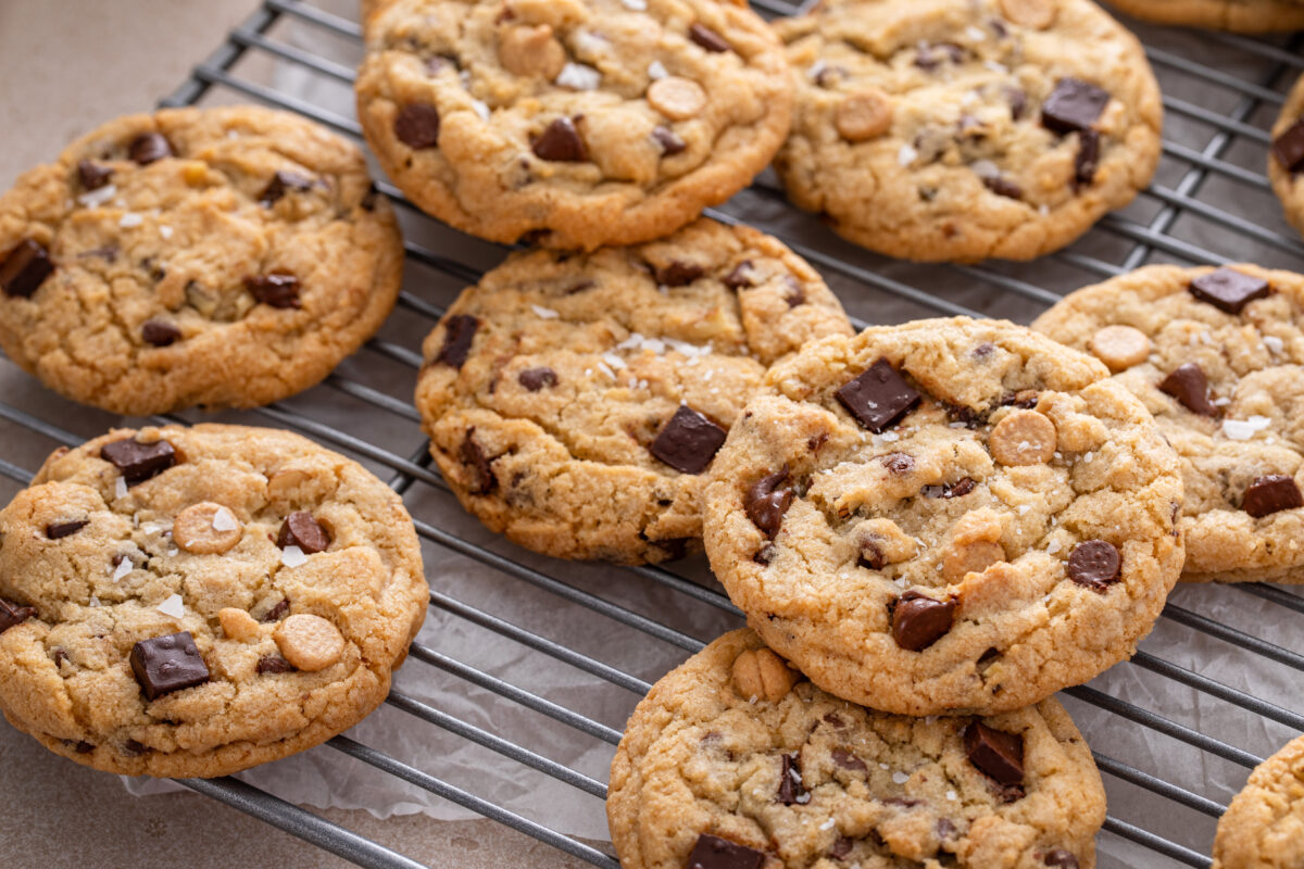 Chocolate chip cookies with chocolate chunks and caramel chips on a cooling rack