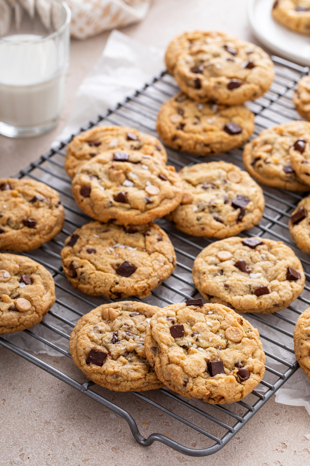Chocolate chip cookies with chocolate chunks and caramel chips on a cooling rack